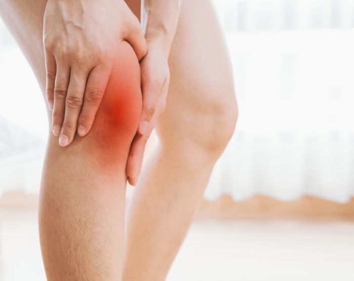 una mano che sfiora delicatamente la pelle o una figura che massaggia una zona dolorante